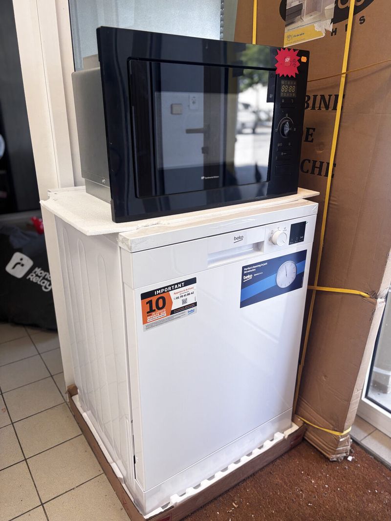 Micro-ondes encastrable noir posé sur un lave-vaisselle blanc, en magasin chez Distribat 82